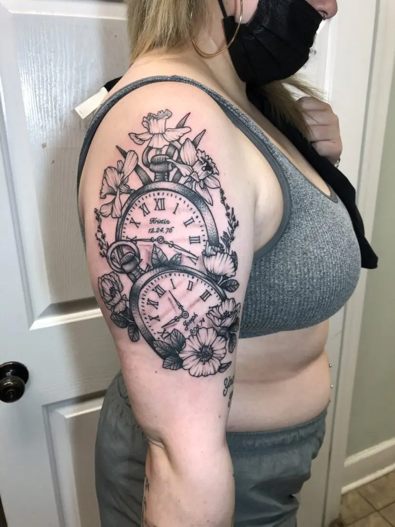 Clock and flower tattoo on the arm of a woman